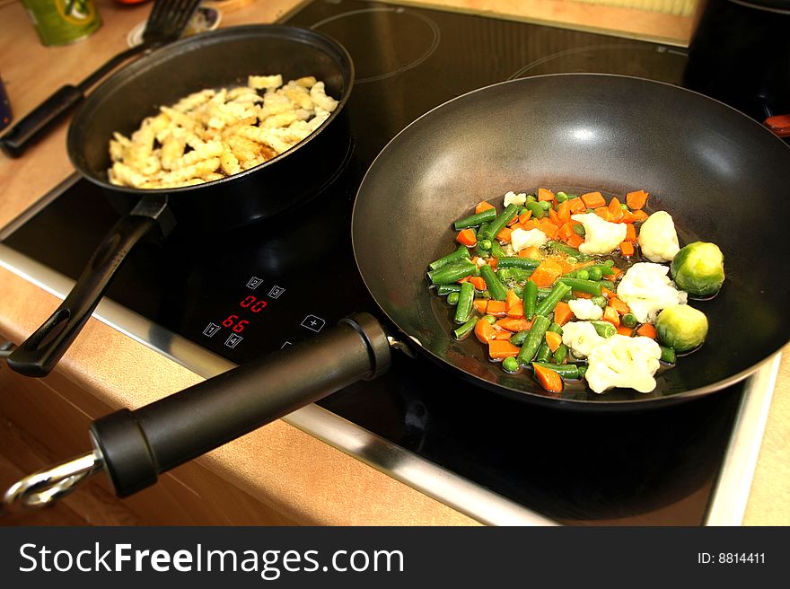 Preparing the meal - stir fry vegetables and potatoes in wok pan. Preparing the meal - stir fry vegetables and potatoes in wok pan