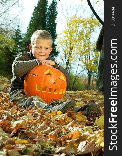 Sitting little boy with halloween pumpkin. Sitting little boy with halloween pumpkin