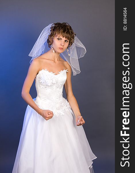 Studio portrait of a aggressive bride wearing a white wedding dress with veil