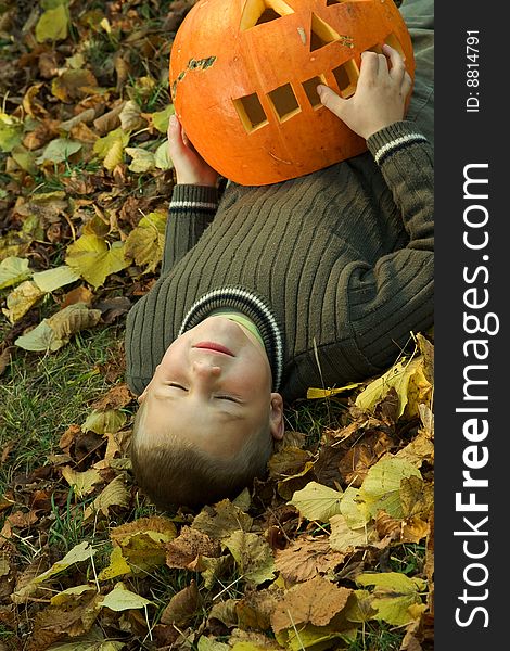Laying little boy with halloween pumpkin. Laying little boy with halloween pumpkin