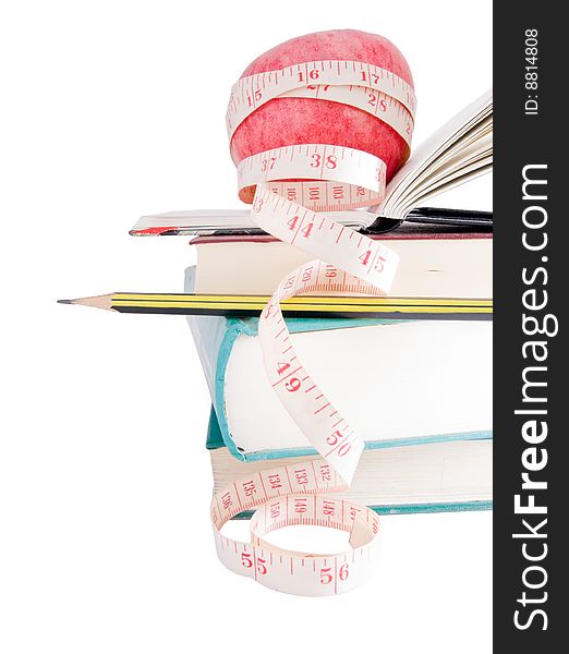 Big ripe red apple with white measure tape around it on pile of books as metaphore of healthy eating and diet. Big ripe red apple with white measure tape around it on pile of books as metaphore of healthy eating and diet