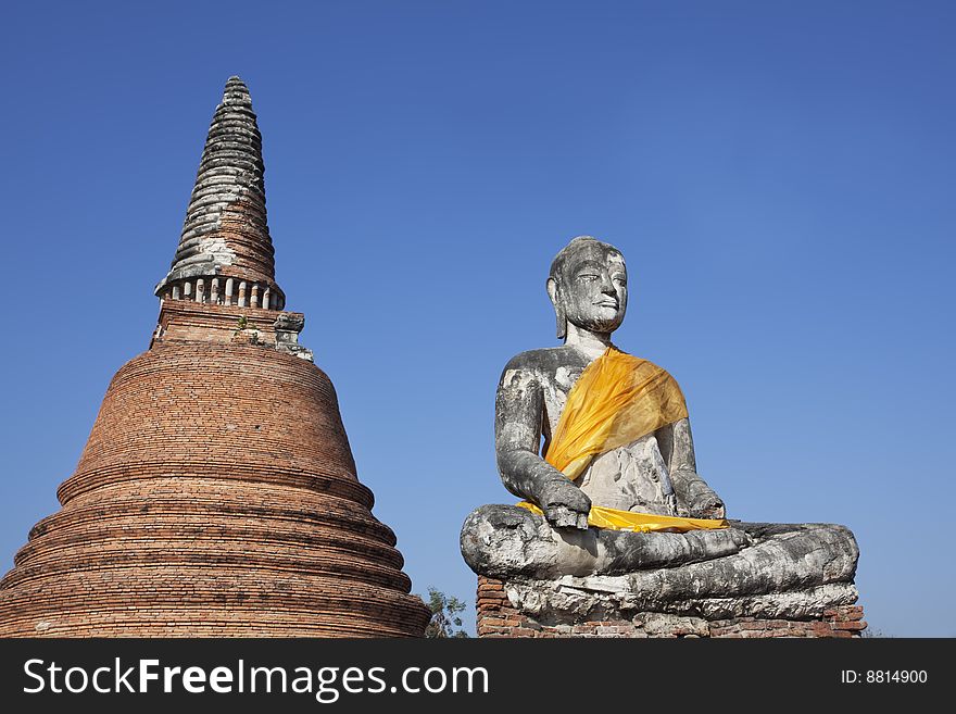 Buddha Statue at Wat Phra Si Sanphet in Ayutthaya, Thailand. Shot against a deep blue sky with a view of a stupa. Buddha Statue at Wat Phra Si Sanphet in Ayutthaya, Thailand. Shot against a deep blue sky with a view of a stupa