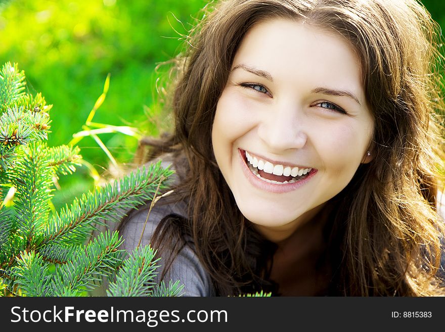 Images of smiling beautiful girl on the grass in sunny day