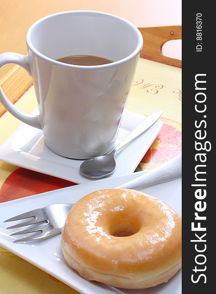 Coffee and doughnut on wooden tray for breakfast