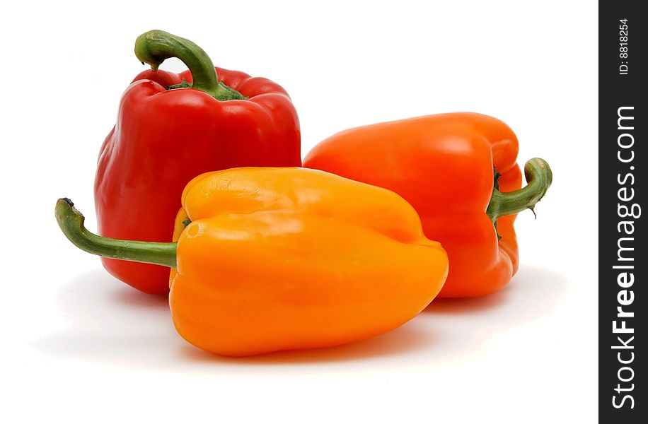 Three sweet bell peppers in red, orange and yellow colors on white background. Three sweet bell peppers in red, orange and yellow colors on white background