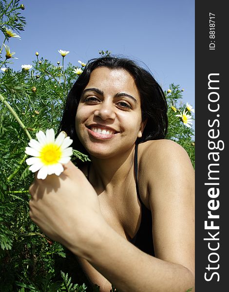 Woman smiling holding a flower. Woman smiling holding a flower
