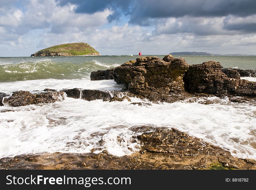 Puffin Island from the Isle of Anglesey with wave coming in over rocks