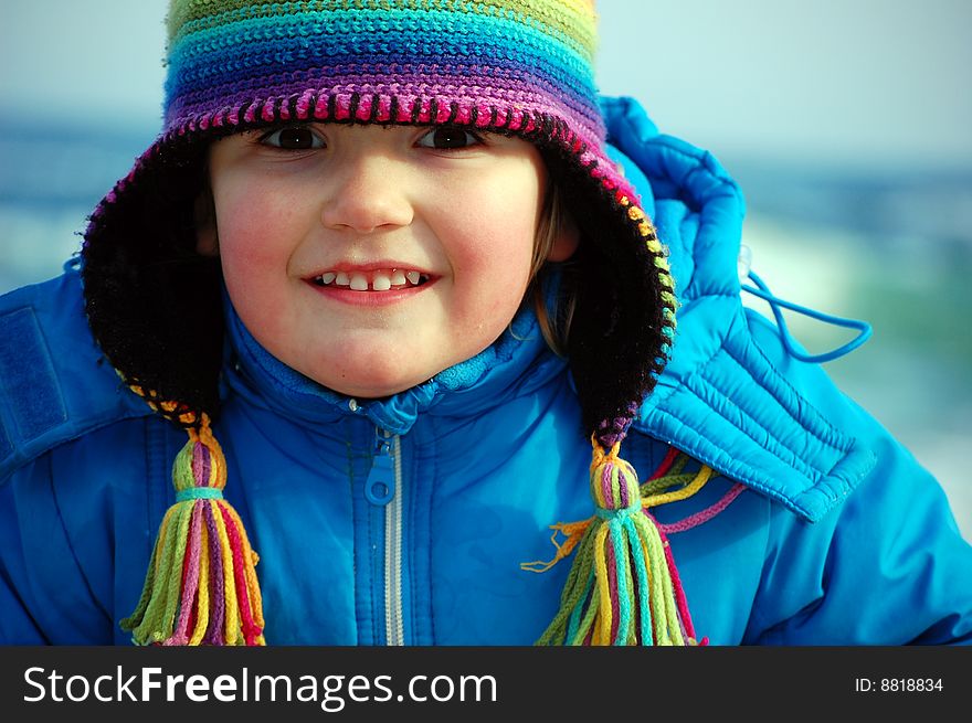 A pretty girl with a rainbow hat smiles with all her senses. A pretty girl with a rainbow hat smiles with all her senses.