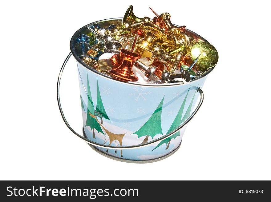 Miniature bucket with Holiday design, filled with brightly colored push pins.  Isolated on a white background. Miniature bucket with Holiday design, filled with brightly colored push pins.  Isolated on a white background.