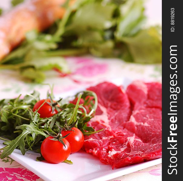 Raw meat with tomatoes and rucola