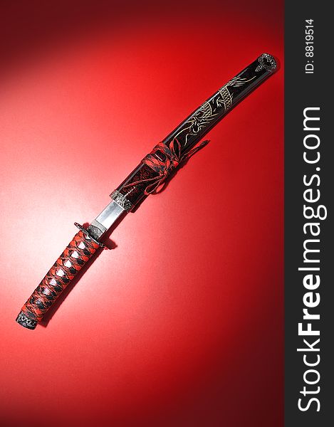 Japanese Tanto sword red dragon isolated on red background. Japanese Tanto sword red dragon isolated on red background