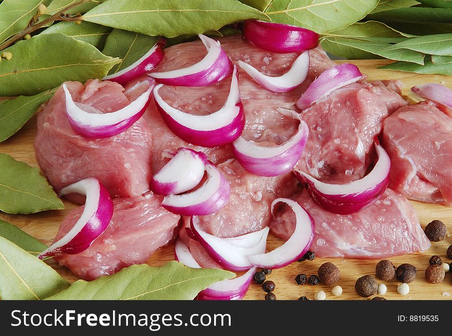 Raw beef meat with spice on wooden board