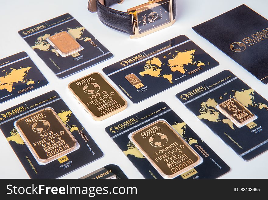 Set of different weight gold bars on decorative blue cars with world map.