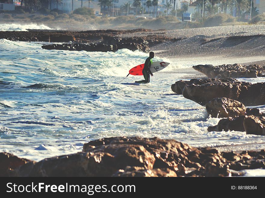 Surfer With Surfboard On Beach