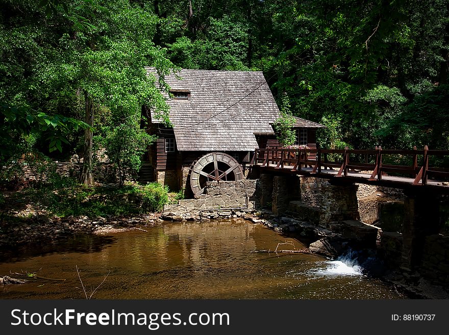 Brown House Near River Trees and Bridge