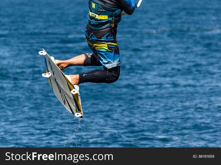 Person in Blue and Black Board Shorts on White Wake Board