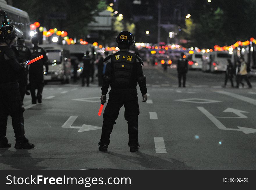 Police officers standing in city streets at night. Police officers standing in city streets at night.