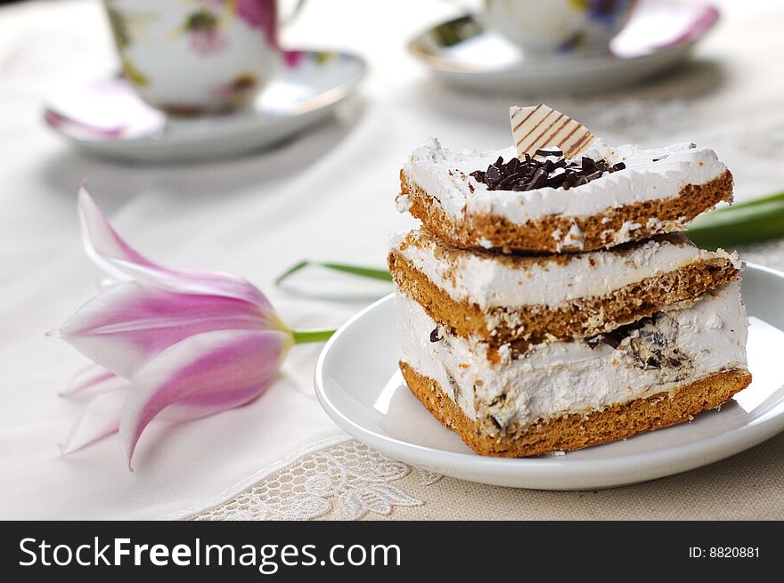 Piece of cake on the background of cups of tea. Piece of cake on the background of cups of tea