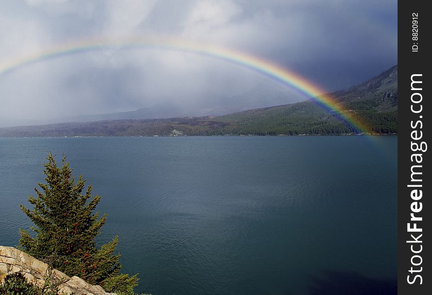 Rainbow over a lake with dark clouds