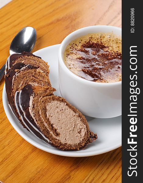 Cup of coffee with dessert on the wooden table