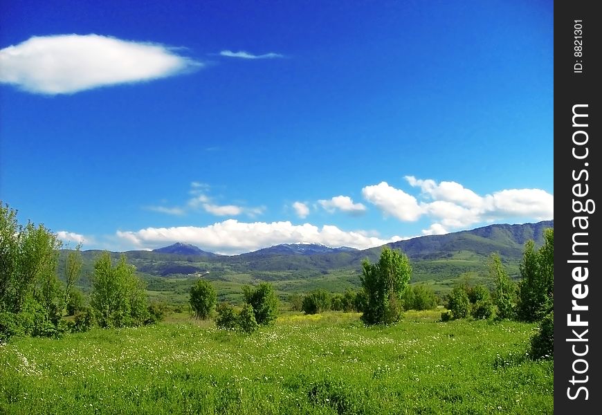 Green meadow with small mountains