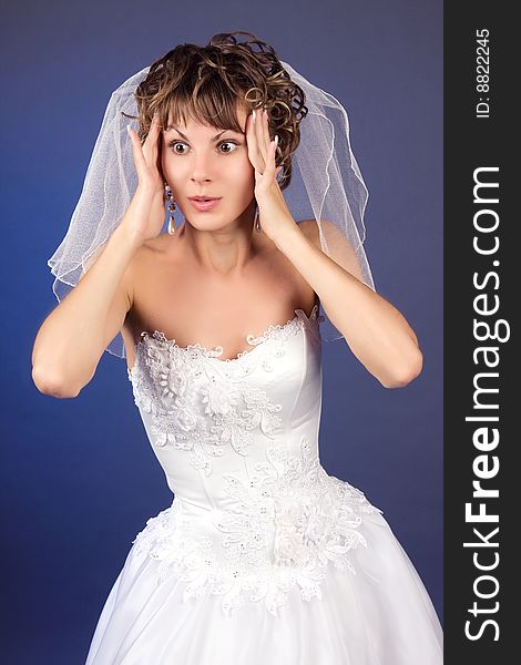 Studio portrait of the surprised young bride isolated against