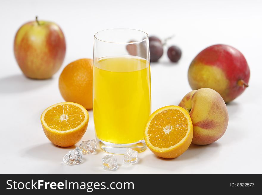 Juice glass with fruits and ice on white background