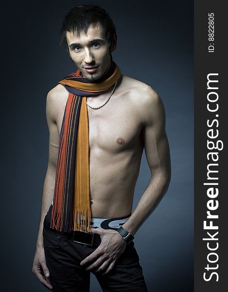 Young fashion male model with athletic body posing in colorful srarf