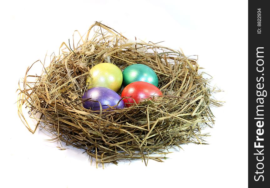 The nest with colour eggs is isolated on a white background