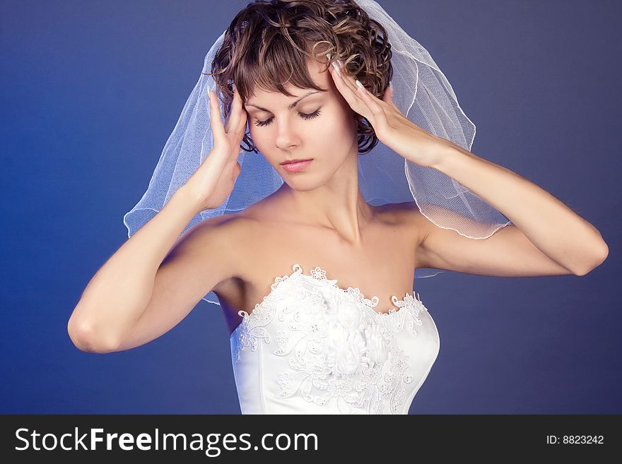 Studio portrait of the young coquettish bride isolated against