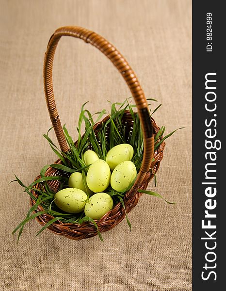 Basket with Easter eggs in grass, selective focus on eggs. Basket with Easter eggs in grass, selective focus on eggs