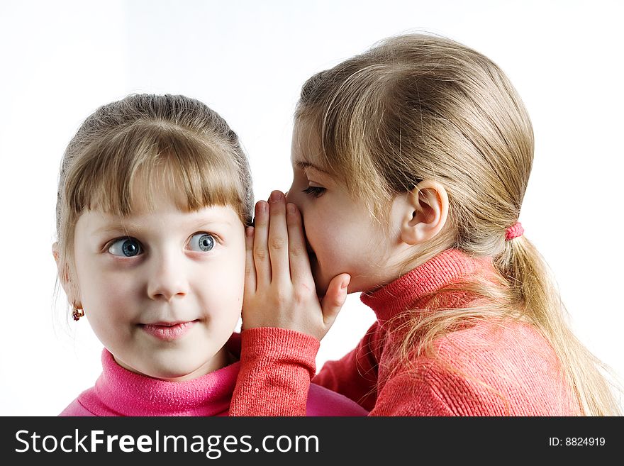 An image of a girl whispering something to surprised girl