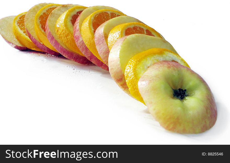 Fruit slicing of apples and oranges on a white background