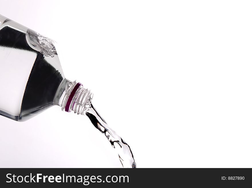 Pouring water from a bottle isolated on white background