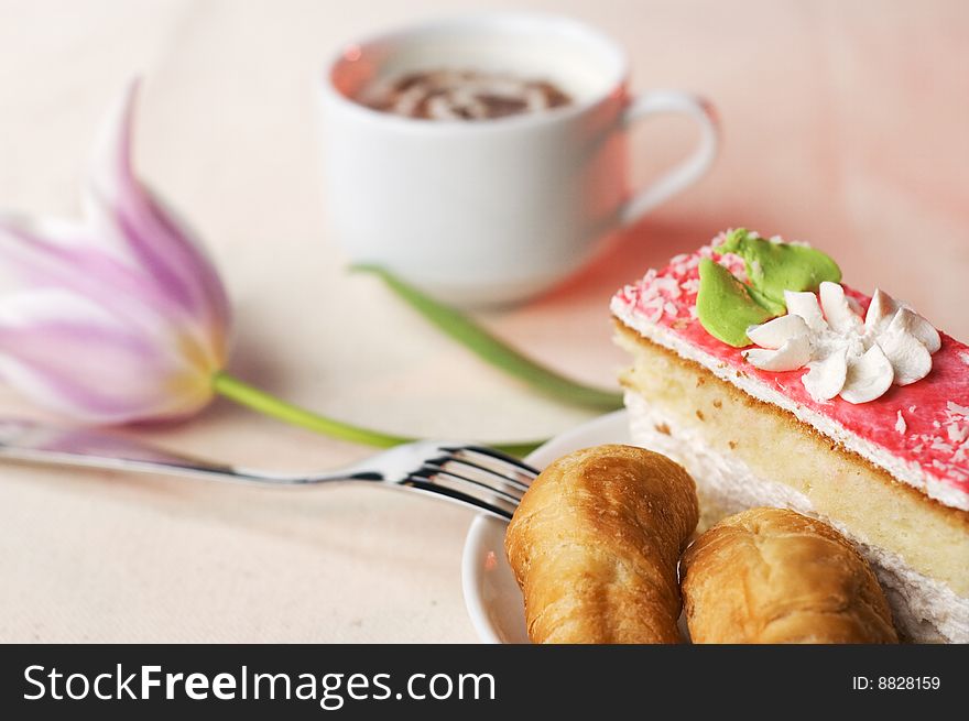 Pastry in the saucer and coffee on the tablecloth. Pastry in the saucer and coffee on the tablecloth