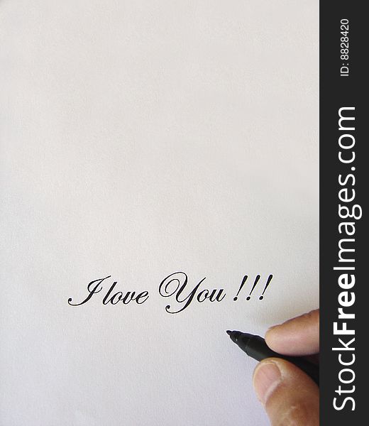 Close up view of the words I LOVE YOU written in classic type and a hand with a black pen