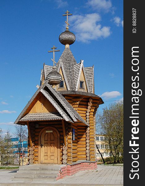 Wooden chapel  on pavinf slab pad at sunny spring noon with blue sky