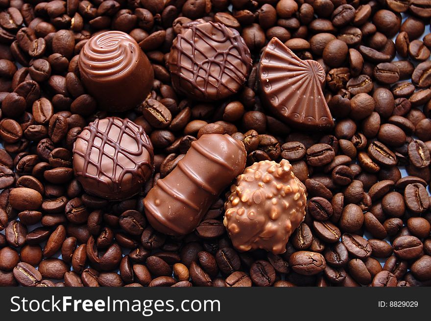Chocolates against coffee in grains