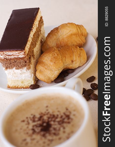 Close-up cup of coffee with dessert on the saucer