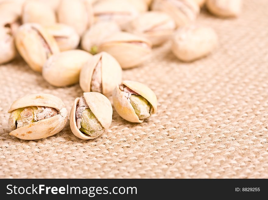 Healthy nuts pistachios on a burlap canvas shallow depth of view. Healthy nuts pistachios on a burlap canvas shallow depth of view