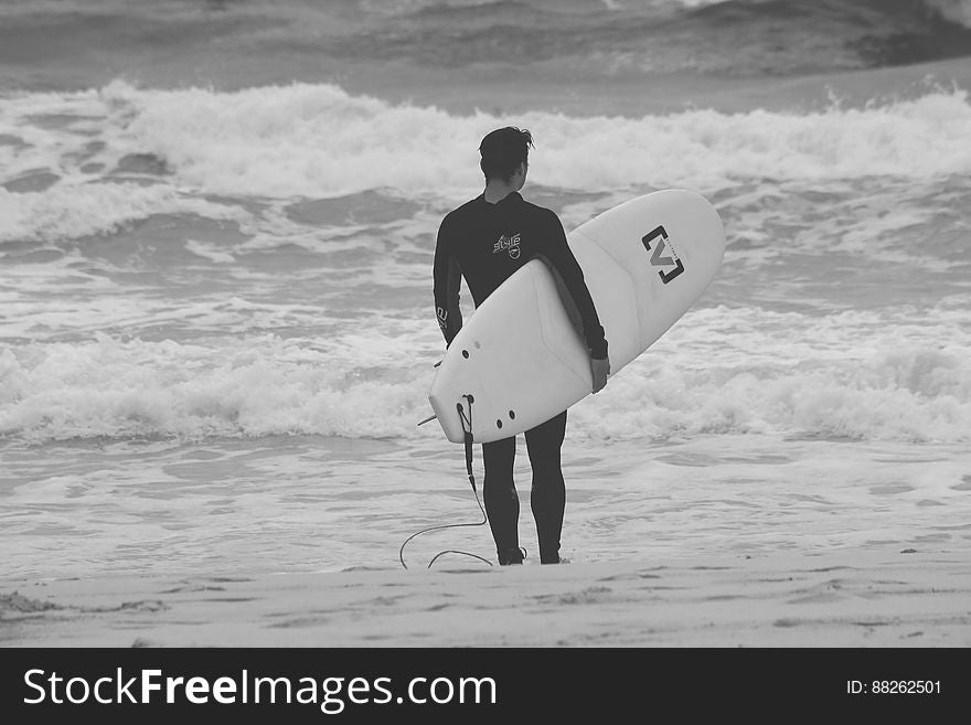 Surfer With Surfboard On Beach