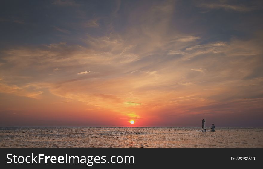 Surfers in Ocean at Sunset