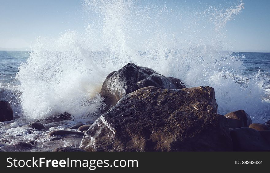 Ocean Wave Splashing Against Rocks