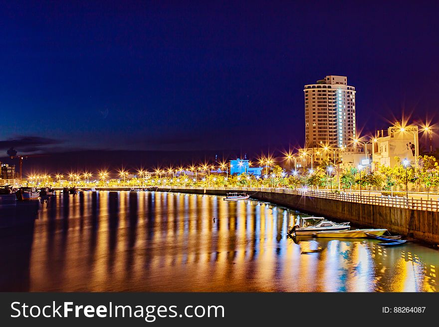 A view of a city with a river passing through it at night. A view of a city with a river passing through it at night.