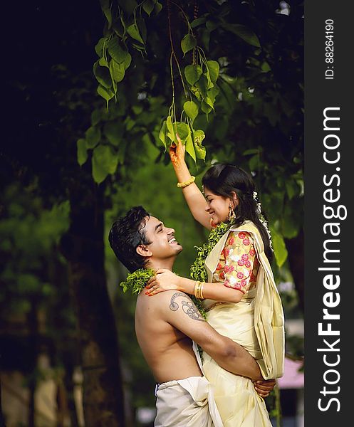 Portrait of young Indian couple embracing outdoors in sunny garden. Portrait of young Indian couple embracing outdoors in sunny garden.