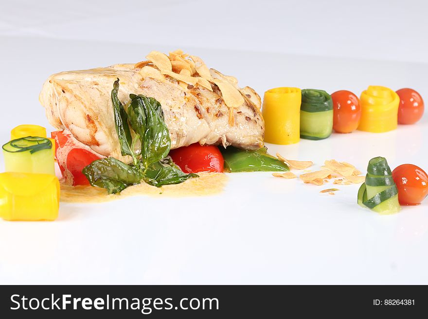 Baked salmon fillet with colorful spirals of fresh vegetables on white. Baked salmon fillet with colorful spirals of fresh vegetables on white.