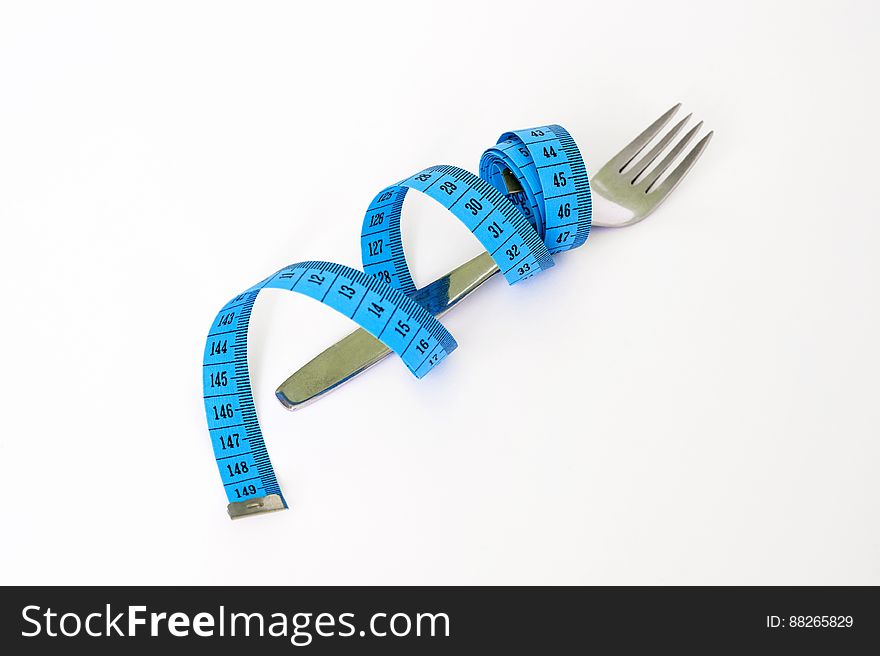 Blue and Black Measuring Tape Wrapped Around a Silver Metal Fork