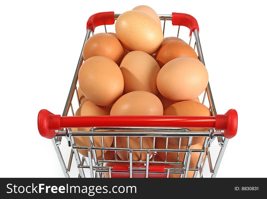 Shopping trolley filled with brown eggs on bright background