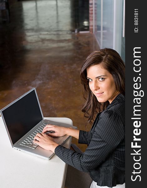 Business woman in modern office with laptop and coffee. Business woman in modern office with laptop and coffee