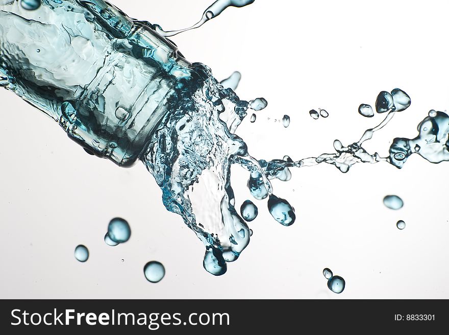 Bottle and creative splashing water.

Isolated on white